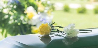 Famed Artist Is Dead At 88 — The Fight Over Him Started YEARS Ago Yellow rose and white carnation on a green casket
