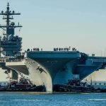 How ONE HIT Can “KILL” a $13B Carrier Aircraft carrier guided by tugboats in a harbor