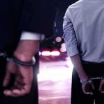 She Was On Trial For A DUI Death — Then Her LAWYER Got Cuffed Two men in handcuffs with police lights in the background