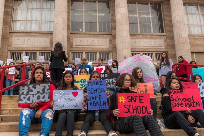 shutterstock_1046281249 Students holding protest signs on school steps