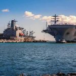 90 Sailors Came Home From Sea — No Cars, Just The BILL Aircraft carrier and support ships docked at a naval harbor