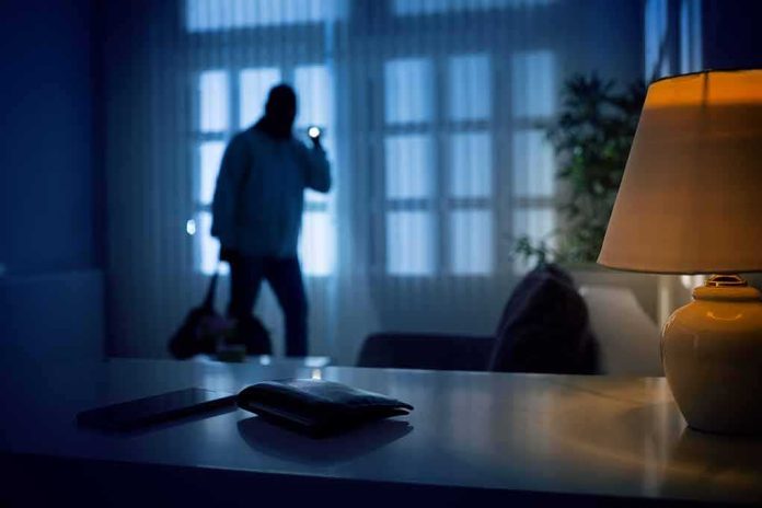 shutterstock_1174180636 Silhouetted intruder in a dim living room at night