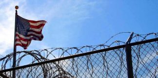 Intruder Hit The Base That Runs Our Iran War — They Won’t Say WHO American flag near barbed wire fence against blue sky