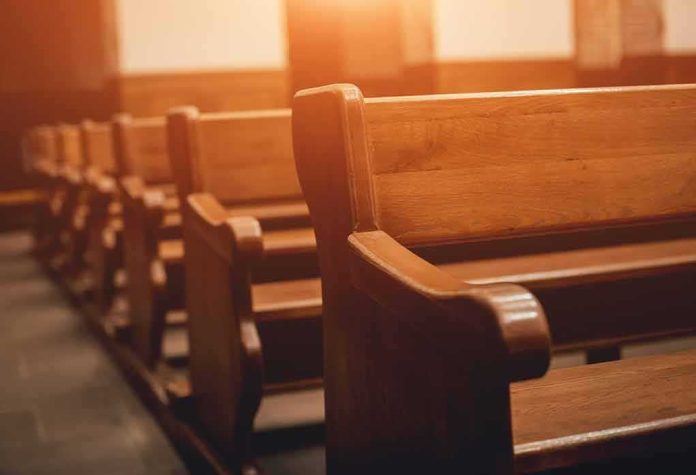 shutterstock_1220552650 Wooden church pews in warm sunlight