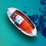 Four Pilots Went Fishing — The Air Force Took Their CATCH Small boat floating over clear turquoise water