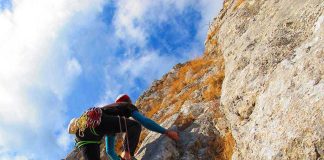 Helicopter Inches From Granite — Then This A climber ascending a rocky cliff under a blue sky