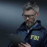 Did The FBI Botch Oklahoma City Bombing Investigation? FBI agent with glasses using a tablet
