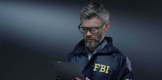 Did The FBI Botch Oklahoma City Bombing Investigation? FBI agent with glasses using a tablet