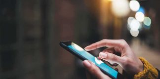 His Screen Said He Was Getting Rich — Until He Tried To Cash OUT Hands using a smartphone outdoors at night