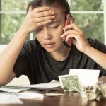 Price Transparency WAR — Hospitals Melt Down! Person on phone reviewing bills at a table