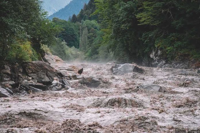 shutterstock_1732590473 Flooded river gorge with fast muddy water and rocks
