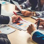 DNC’s SHOCKING Autopsy HIDES Truth business team reviewing charts at a meeting table