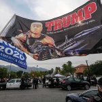 TRUMP House Beating Leaves Veteran Dead Large political flag over street protest with police and cars below