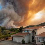 State Farm Faces $4M Hit—Wildfire Drama Suburban house under towering wildfire smoke plume