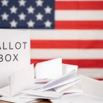 Trump’s Candidate Crushes Massie: A Martyr’s Tale? Ballot box with papers in front of an American flag