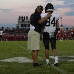 Hidden Phone Stuns Team – Coach Cuffed football coach with arm around player number 84 on sideline
