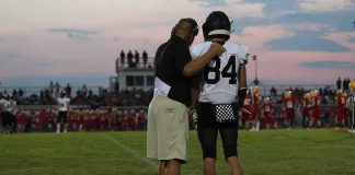 Hidden Phone Stuns Team – Coach Cuffed football coach with arm around player number 84 on sideline