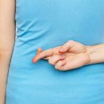Fake Pregnancy BOMBSHELL Shocks Court Person with crossed fingers behind their back