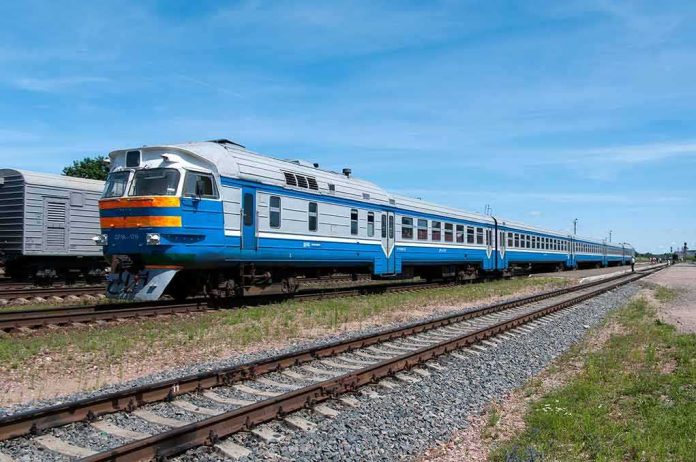 shutterstock_2108659823-1 Blue and white passenger train on railway tracks