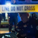 Terror Raid Turns Deadly — Then Silence Police officer examines evidence at night behind caution tape