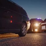 Trooper Dad Of Three Stopped The WRONG Car On I-65 Police officer at patrol car during traffic stop at dusk