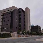Sinaloa Governor Charged—Cartel Links Exposed? Modern concrete and dark glass government building on a cloudy day
