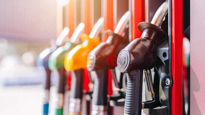 shutterstock_2400584577 Close-up of fuel pump nozzles at a gas station