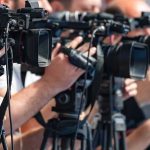 Flood Horror: Infant Snatched from Death’s Grip television cameras on tripods at a media event