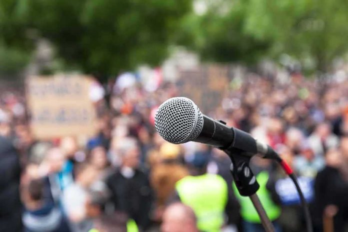 shutterstock_420747343 microphone on stand in front of a blurred crowd
