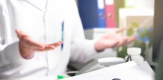 Doctor Fined BIG For Refusing THIS! Doctor gesturing during consultation with patient holding paper with question mark
