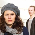 Man LURKED By Young Woman’s Car — His PAST Is CHILLING woman in gray beret and scarf with man blurred in background
