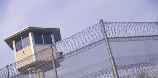 Church KILLER Blamed ONE Thing — Supreme Court Just ANSWERED Prison watchtower behind barbed wire fencing