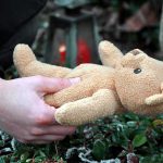 Gunman KILLED Little Kids — Look WHO They Were To Him Hands holding a teddy bear near a grave