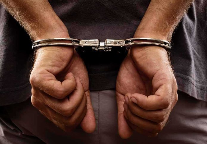 shutterstock_135865661-1 Hands in handcuffs behind back