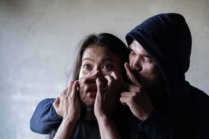 shutterstock_1381990856 Woman restrained by hooded person covering her mouth