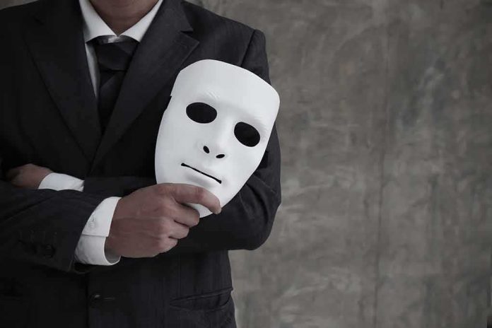 shutterstock_1494047510 man in suit holding a white mask