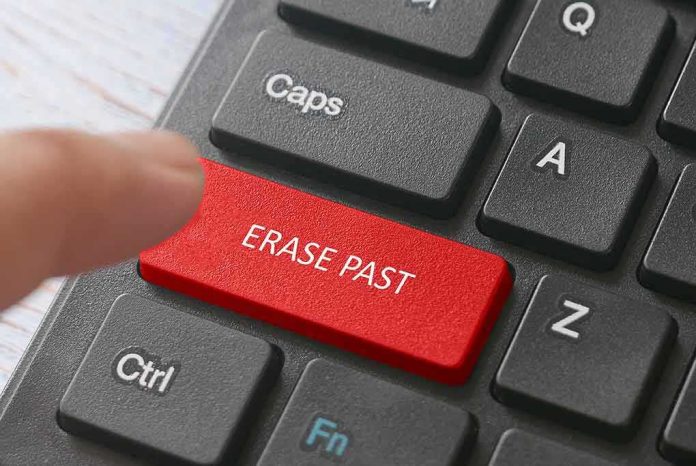 Finger pressing a red keyboard key labeled erase past