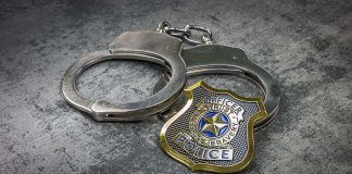 Cop Accused Of Grooming A Girl — Look Where He MET Her Handcuffs and police badge on a gray surface