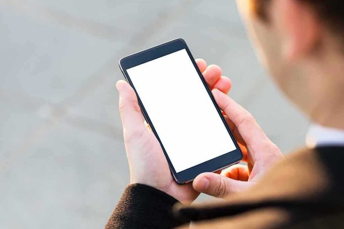 shutterstock_329288624-1 Person holding smartphone with blank white screen