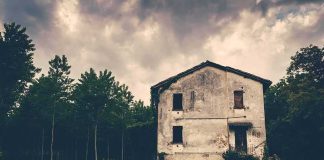 Backup Cop At Death Scene Now ACCUSED abandoned house in a field under stormy sky