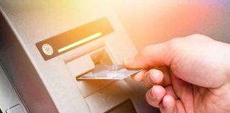ATMs In 47 States Poured Out CASH — Who It Was FOR Is Far Worse Hand inserting bank card into ATM slot