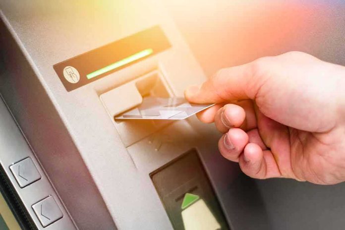 shutterstock_570926716 Hand inserting bank card into ATM slot