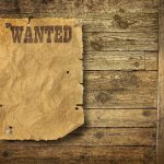 Girl, 7, Stabbed On A Sidewalk — Attacker Was Already WANTED A vintage wanted poster pinned to a wooden wall