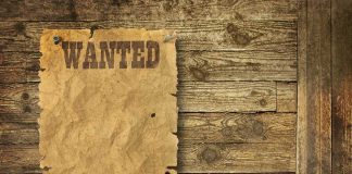Girl, 7, Stabbed On A Sidewalk — Attacker Was Already WANTED A vintage wanted poster pinned to a wooden wall